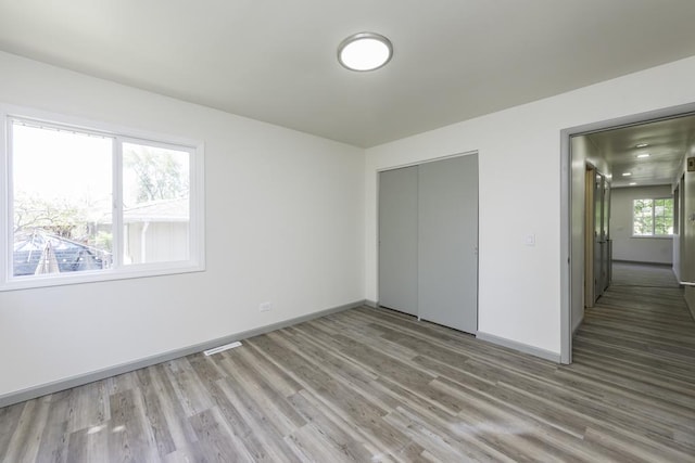 1525 Grove Dr, Round Lake Beach, IL 60073 - unfurnished bedroom with light wood finished floors, baseboards, and a closet