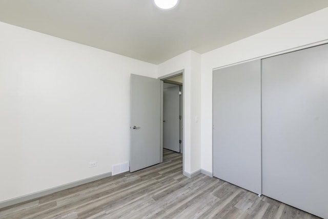 1525 Grove Dr, Round Lake Beach, IL 60073 - unfurnished bedroom with light wood-style floors, a closet, and baseboards