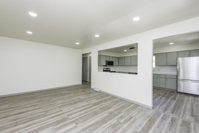 1525 Grove Dr, Round Lake Beach, IL 60073 - unfurnished living room with light wood finished floors, recessed lighting, and baseboards