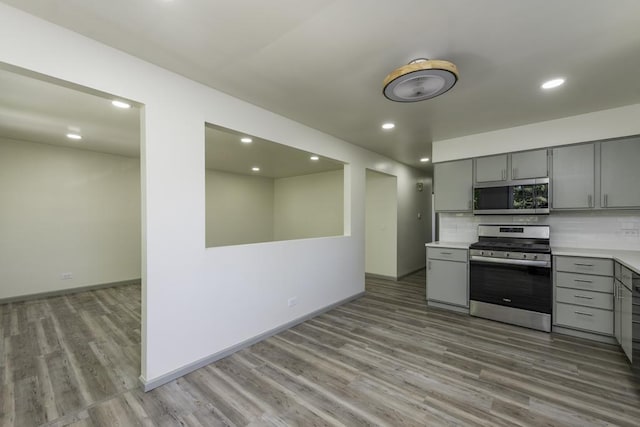 1525 Grove Dr, Round Lake Beach, IL 60073 - kitchen featuring appliances with stainless steel finishes, gray cabinets, wood finished floors, light countertops, and recessed lighting