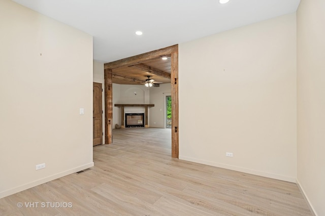 3515 Kings Lair Dr, Spring Grove, IL 60081 - spare room featuring a glass covered fireplace, a ceiling fan, beam ceiling, recessed lighting, and light wood-type flooring
