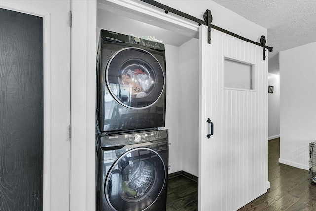 956 E Orleans St, Paxton, IL 60957 - washroom featuring stacked washer / drying machine, a barn door, wood finished floors, baseboards, and a textured ceiling