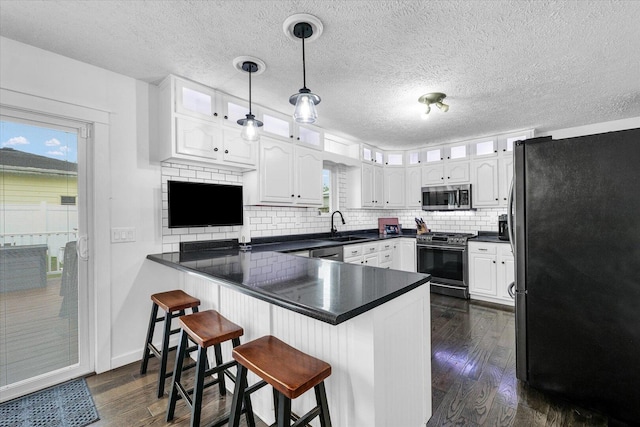 956 E Orleans St, Paxton, IL 60957 - kitchen with appliances with stainless steel finishes, a peninsula, white cabinets, glass insert cabinets, and a sink