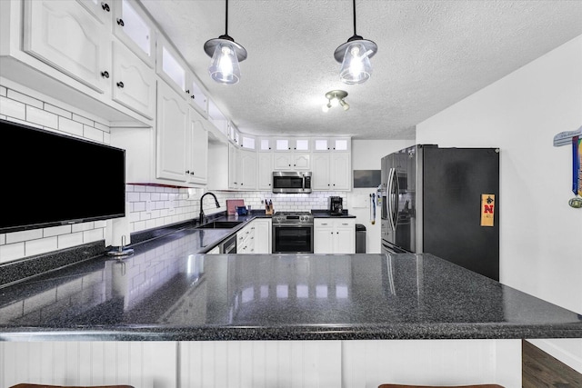 956 E Orleans St, Paxton, IL 60957 - kitchen with appliances with stainless steel finishes, a sink, a peninsula, white cabinetry, and decorative backsplash