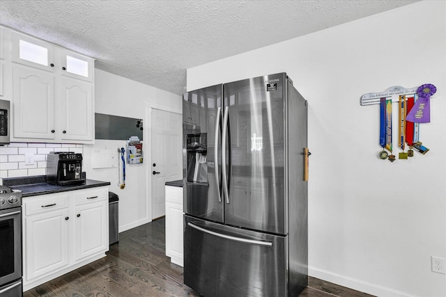 956 E Orleans St, Paxton, IL 60957 - kitchen with appliances with stainless steel finishes, dark wood-style flooring, dark countertops, white cabinetry, and a textured ceiling