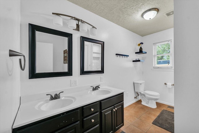 956 E Orleans St, Paxton, IL 60957 - bathroom with double vanity, a textured ceiling, toilet, baseboards, and tile patterned floors