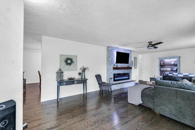 956 E Orleans St, Paxton, IL 60957 - living room featuring a large fireplace, a textured ceiling, wood finished floors, and ceiling fan