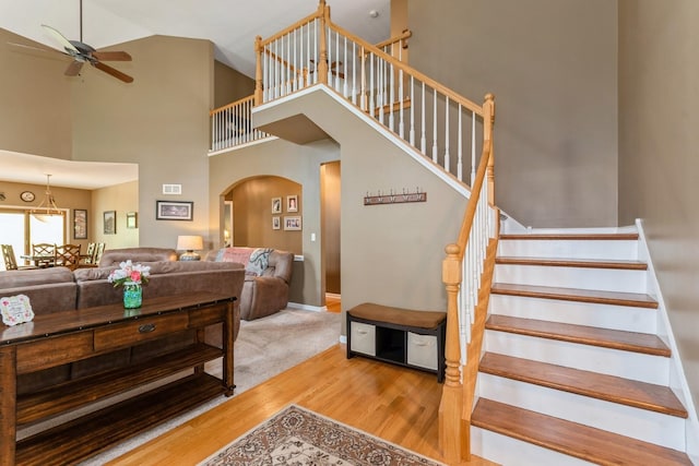 13555 Golden Eagle Cir, Plainfield, IL 60544 - staircase with ceiling fan, arched walkways, wood finished floors, high vaulted ceiling, and baseboards