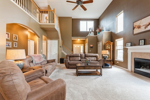 13555 Golden Eagle Cir, Plainfield, IL 60544 - living room with a high ceiling, carpet flooring, ceiling fan, arched walkways, and stairs