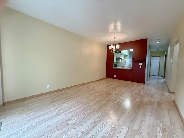 727 S Ashland Ave Unit C, Chicago, IL 60607 - empty room featuring a chandelier, light wood-style floors, and baseboards
