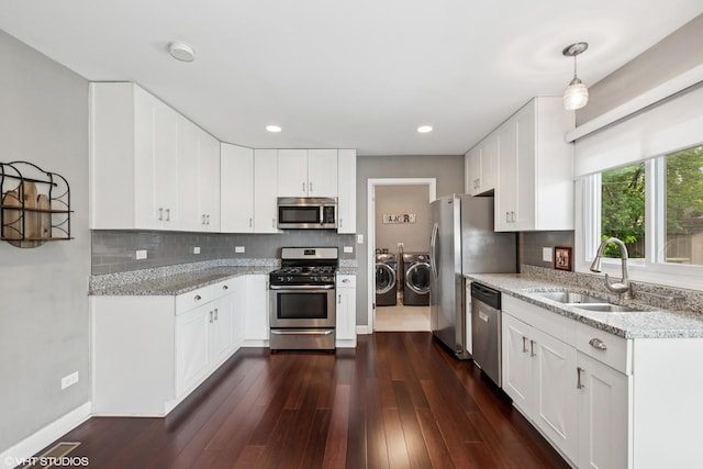 5142 Deerpath Rd, Oak Forest, IL 60452 - kitchen with appliances with stainless steel finishes, washing machine and dryer, a sink, light stone countertops, and decorative backsplash