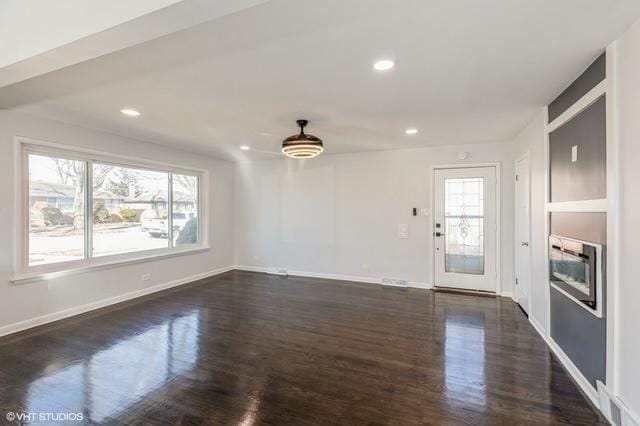 16361 Greenwood Ave, South Holland, IL 60473 - unfurnished living room featuring healthy amount of natural light, dark wood-type flooring, baseboards, recessed lighting, and a glass covered fireplace