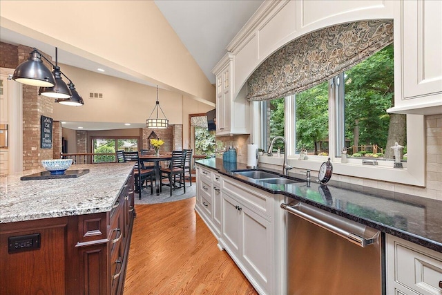 10348 Woburn Ct, Orland Park, IL 60462 - kitchen featuring dishwasher, lofted ceiling, backsplash, white cabinets, and dark stone counters
