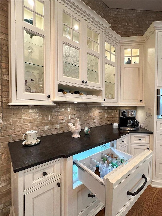 10348 Woburn Ct, Orland Park, IL 60462 - kitchen featuring backsplash, dark countertops, glass insert cabinets, and white cabinetry