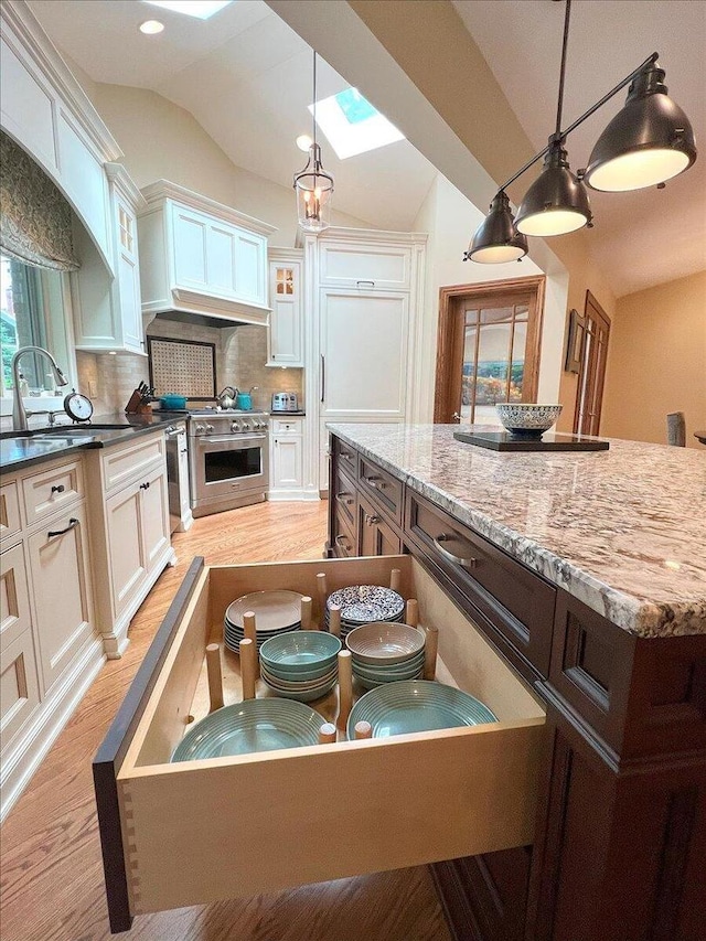 10348 Woburn Ct, Orland Park, IL 60462 - kitchen with high end range, lofted ceiling, light wood-style floors, decorative backsplash, and white cabinetry