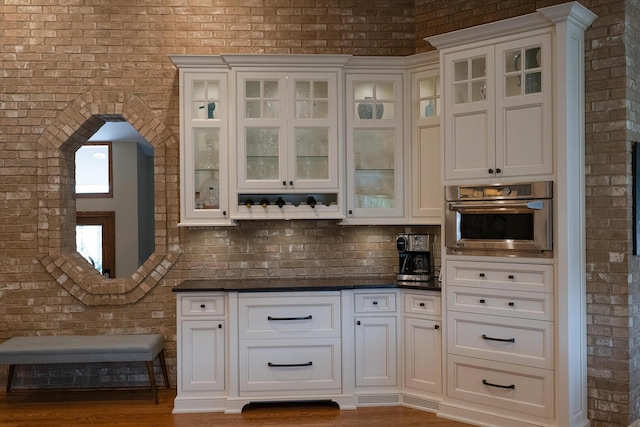 10348 Woburn Ct, Orland Park, IL 60462 - bar featuring brick wall, oven, wood finished floors, and tasteful backsplash