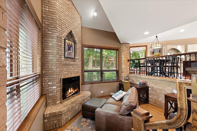 10348 Woburn Ct, Orland Park, IL 60462 - living area with vaulted ceiling, a brick fireplace, wood finished floors, and brick wall