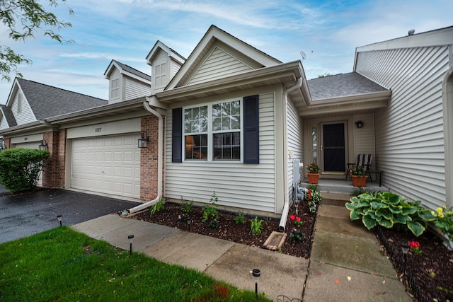 1027 Fairway Dr, Fox Lake, IL 60020 - view of front facade with a garage, asphalt driveway, brick siding, and a shingled roof