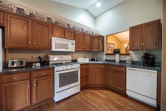 1027 Fairway Dr, Fox Lake, IL 60020 - kitchen with white appliances, a sink, brown cabinets, wood finished floors, and high vaulted ceiling
