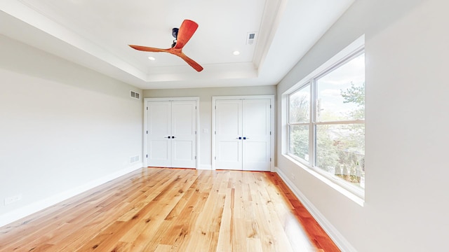 1326 N Race Ave, Arlington Heights, IL 60004 - unfurnished bedroom with a raised ceiling, light wood-type flooring, multiple closets, baseboards, and recessed lighting