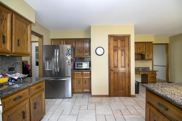 454 Hemlock Ln, Roselle, IL 60172 - kitchen featuring stainless steel fridge with ice dispenser, decorative backsplash, brown cabinets, and dark stone countertops