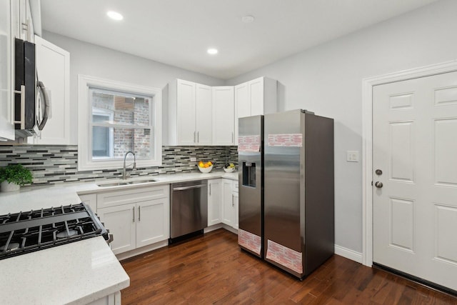 8019 S Bishop St, Chicago, IL 60620 - kitchen with stainless steel appliances, a sink, decorative backsplash, dark wood-style flooring, and white cabinetry
