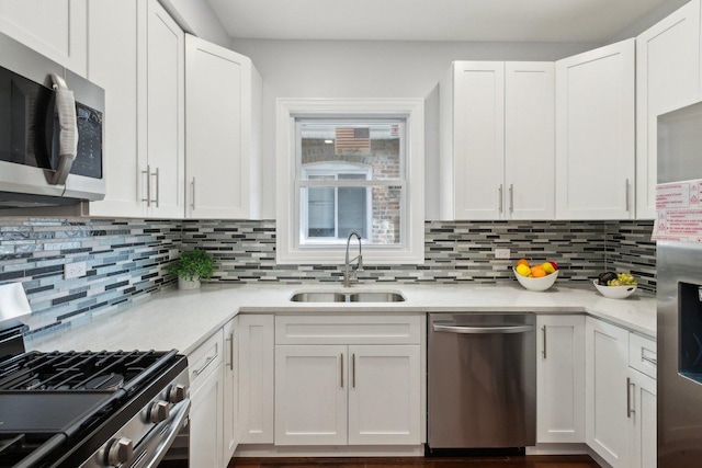 8019 S Bishop St, Chicago, IL 60620 - kitchen with stainless steel appliances, a sink, decorative backsplash, dark wood-style flooring, and white cabinetry