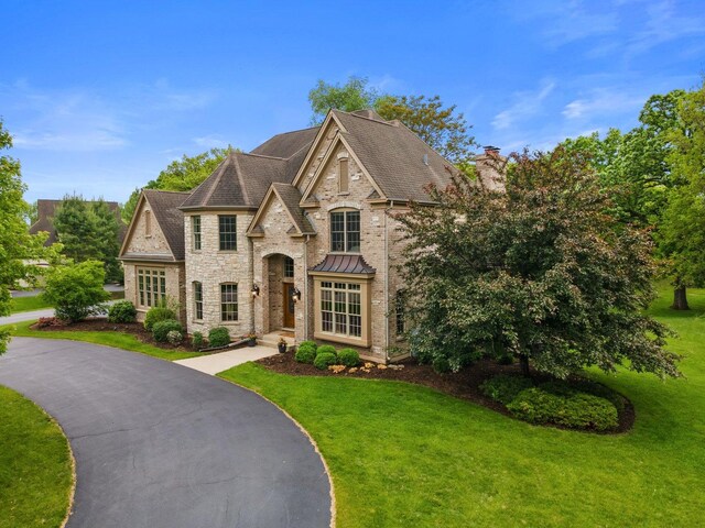 28809 W Harvest Glen Cir, Cary, IL 60013 - french country style house featuring a front lawn, stone siding, a chimney, and a shingled roof
