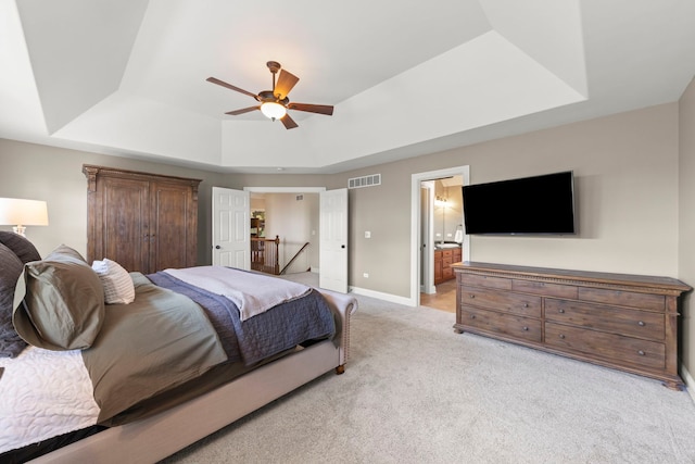 12923 Grande Pines Blvd, Plainfield, IL 60585 - bedroom with a tray ceiling, light carpet, baseboards, ceiling fan, and connected bathroom