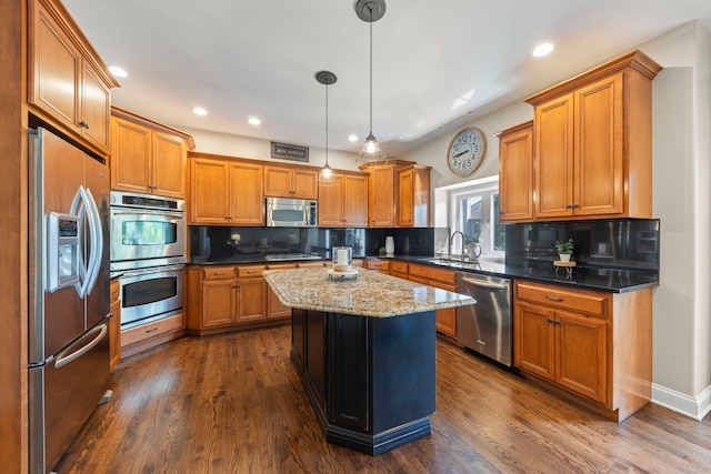 12923 Grande Pines Blvd, Plainfield, IL 60585 - kitchen featuring appliances with stainless steel finishes, brown cabinets, a center island, tasteful backsplash, and recessed lighting