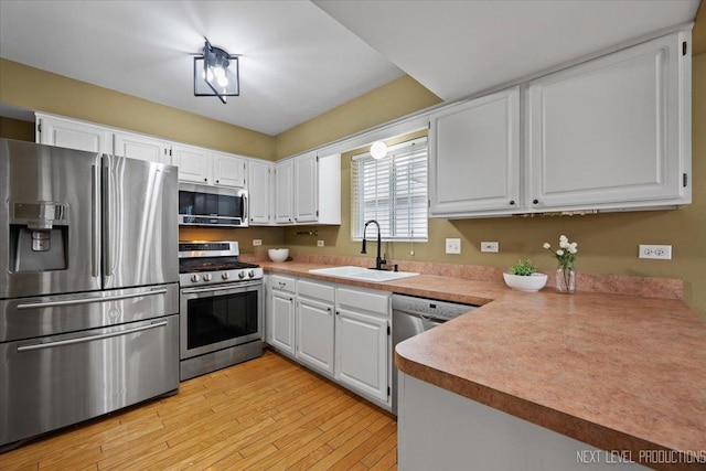 1839 Tamahawk Ln, Naperville, IL 60564 - kitchen featuring stainless steel appliances, a sink, white cabinets, light wood-style floors, and light countertops
