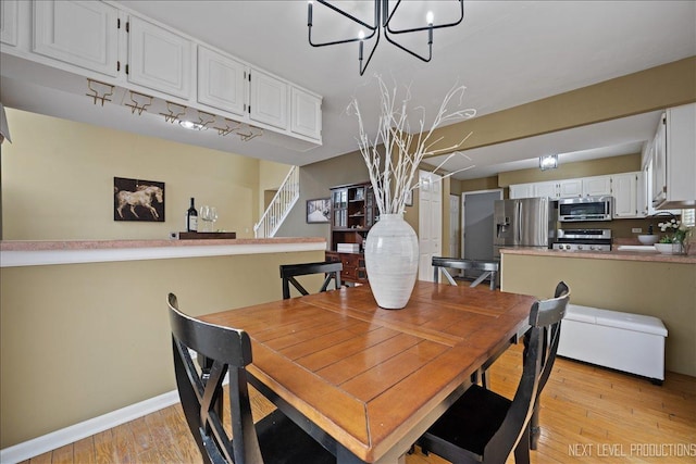 1839 Tamahawk Ln, Naperville, IL 60564 - dining space featuring a chandelier, stairway, light wood finished floors, and baseboards