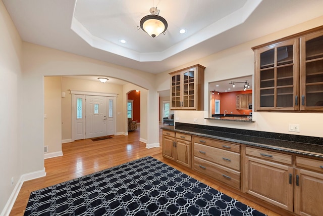 1912 Indian Trl, Kankakee, IL 60901 - kitchen featuring arched walkways, light wood finished floors, a raised ceiling, glass insert cabinets, and recessed lighting