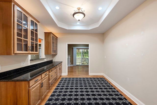 1912 Indian Trl, Kankakee, IL 60901 - kitchen with light wood-style flooring, glass insert cabinets, dark stone countertops, recessed lighting, and baseboards