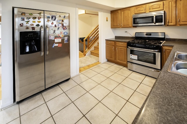 1065 Irwin Ave, Des Plaines, IL 60018 - kitchen featuring appliances with stainless steel finishes, dark countertops, light tile patterned flooring, and brown cabinets