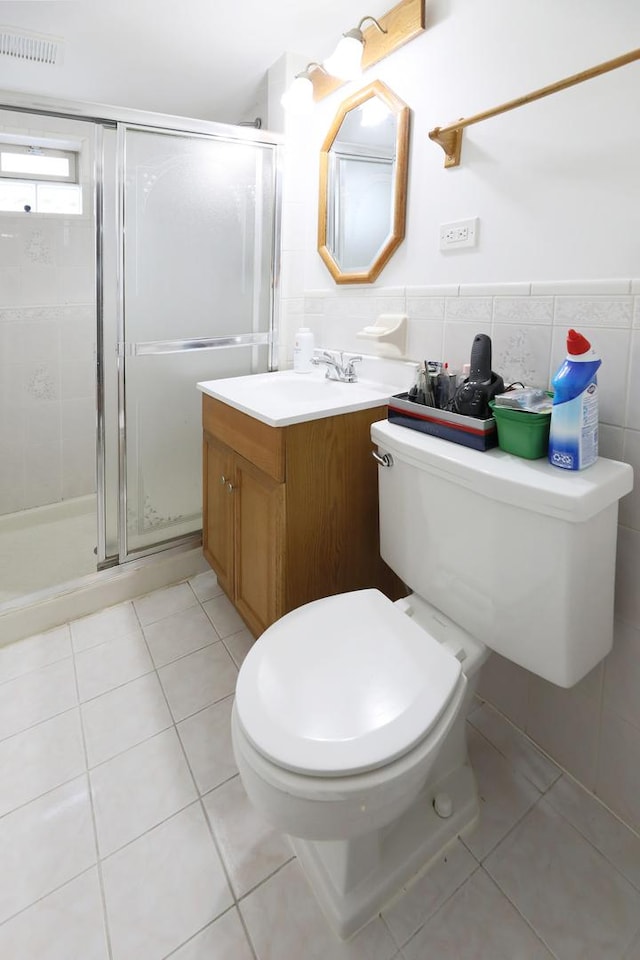 1065 Irwin Ave, Des Plaines, IL 60018 - bathroom with vanity, toilet, a stall shower, tile patterned floors, and tile walls