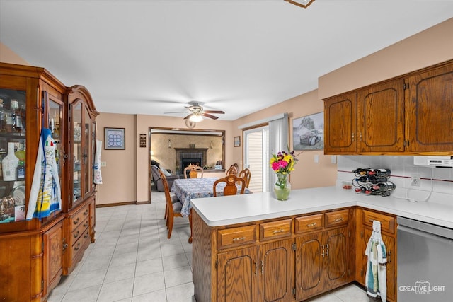 1359 Pine St, Batavia, IL 60510 - kitchen with stainless steel dishwasher, a peninsula, a ceiling fan, a brick fireplace, and light countertops