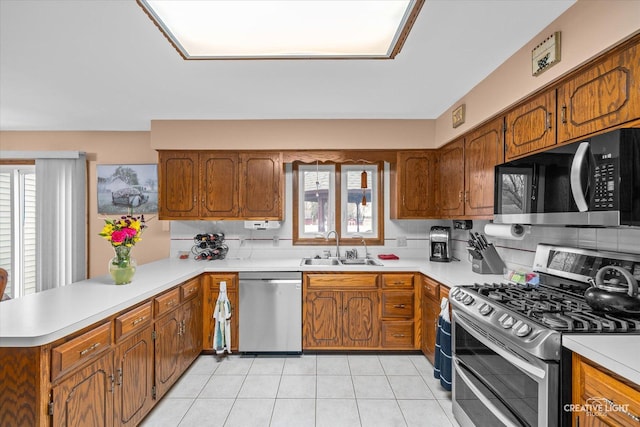 1359 Pine St, Batavia, IL 60510 - kitchen with appliances with stainless steel finishes, a sink, a peninsula, light countertops, and brown cabinetry