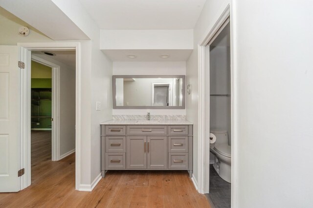 3950 Dundee Rd Unit 101, Northbrook, IL 60062 - bathroom with wood finished floors, toilet, vanity, and baseboards