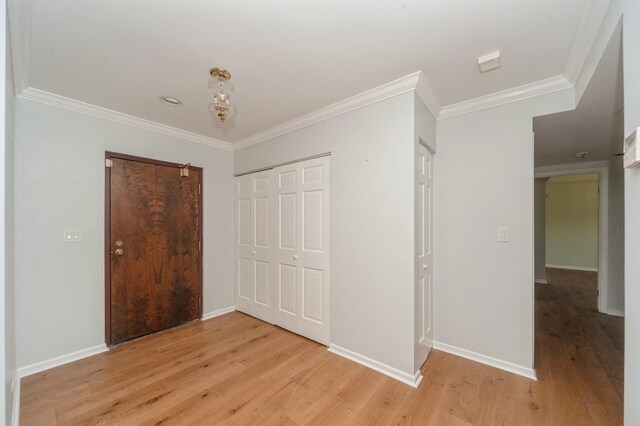 3950 Dundee Rd Unit 101, Northbrook, IL 60062 - unfurnished bedroom with light wood-style floors, crown molding, a closet, and baseboards