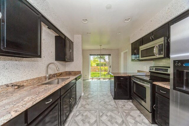 3950 Dundee Rd Unit 101, Northbrook, IL 60062 - kitchen with stainless steel appliances, a sink, light stone counters, and recessed lighting