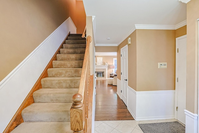 1730 Napoleon Dr, Naperville, IL 60565 - staircase with tile patterned floors, a glass covered fireplace, and crown molding