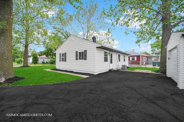 1306 Schriber Ave, Joliet, IL 60435 - view of front of property with cooling unit, a front yard, driveway, and a chimney