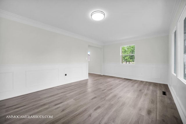 1306 Schriber Ave, Joliet, IL 60435 - unfurnished room with crown molding, a wainscoted wall, wood finished floors, and a decorative wall