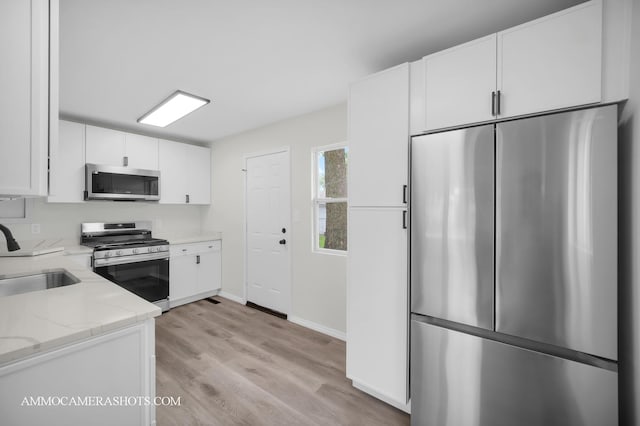 1306 Schriber Ave, Joliet, IL 60435 - kitchen with appliances with stainless steel finishes, a sink, white cabinetry, and light stone countertops