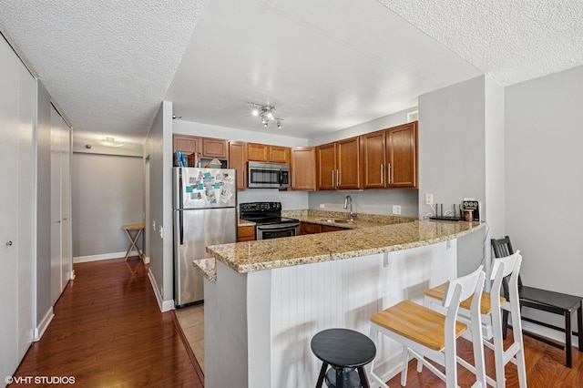 474 N Lake Shore Dr Unit 1701, Chicago, IL 60611 - kitchen featuring appliances with stainless steel finishes, a sink, brown cabinets, a peninsula, and light stone counters