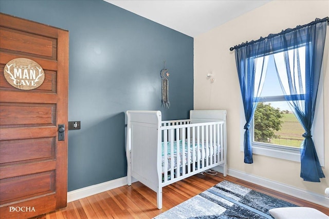 32900 N 2000 E Rd, Dwight, IL 60420 - bedroom with baseboards, wood finished floors, and a crib