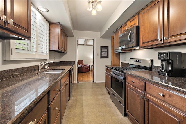 20424 Ithaca Rd, Olympia Fields, IL 60461 - kitchen with appliances with stainless steel finishes, a sink, baseboards, dark stone countertops, and brown cabinetry