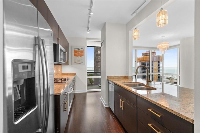 505 N Mcclurg Ct Unit 2003, Chicago, IL 60611 - kitchen featuring appliances with stainless steel finishes, a sink, dark wood-style floors, track lighting, and light stone counters