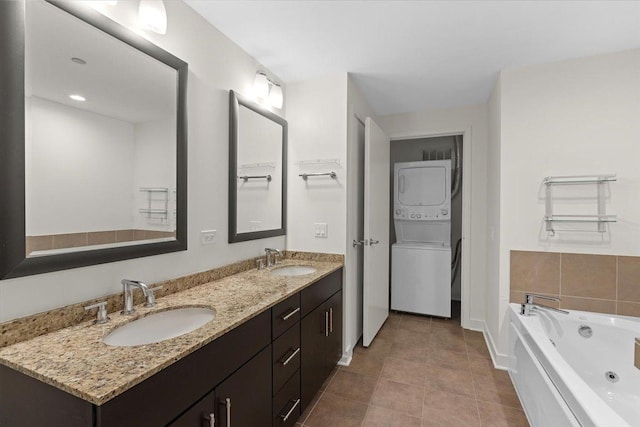 505 N Mcclurg Ct Unit 2003, Chicago, IL 60611 - bathroom featuring stacked washer and clothes dryer, double vanity, a tub with jets, tile patterned flooring, and baseboards